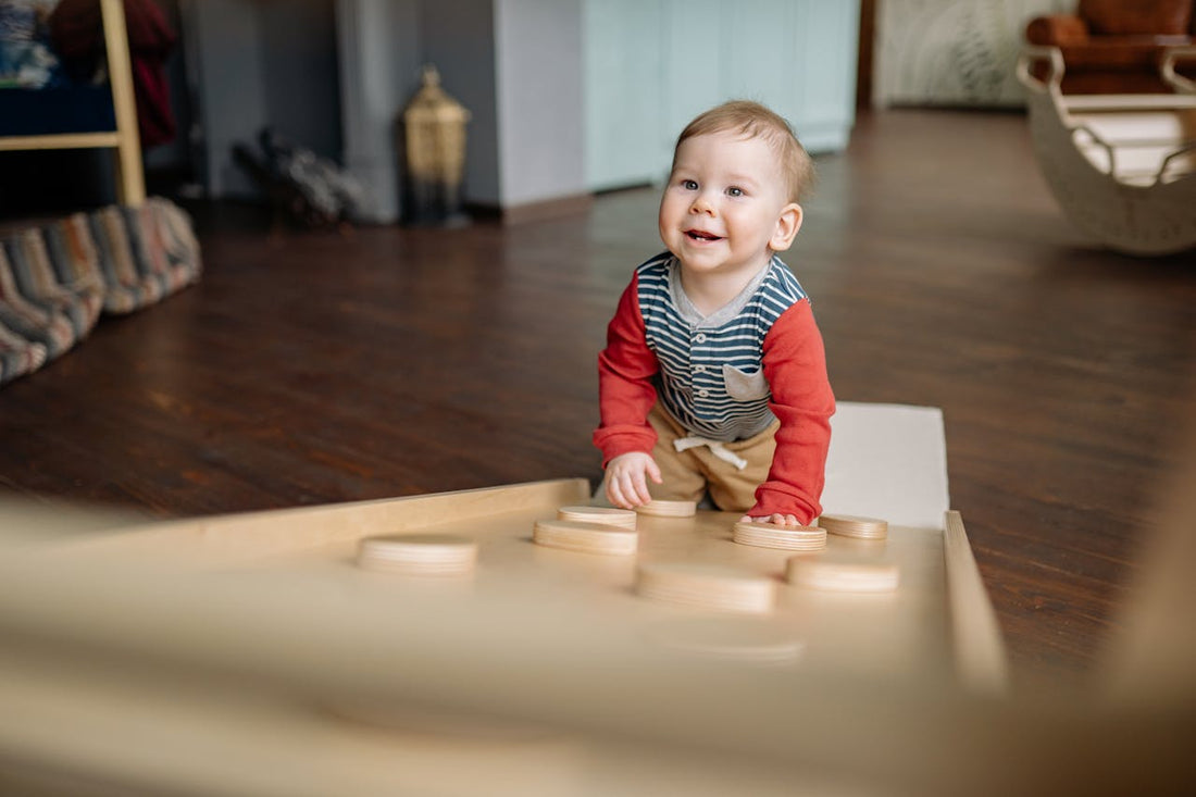 Bébé souriant et curieux, allongé sur un tapis d'éveil coloré, explorant différents jouets sensoriels en tissu et bois, stimulant ses sens.