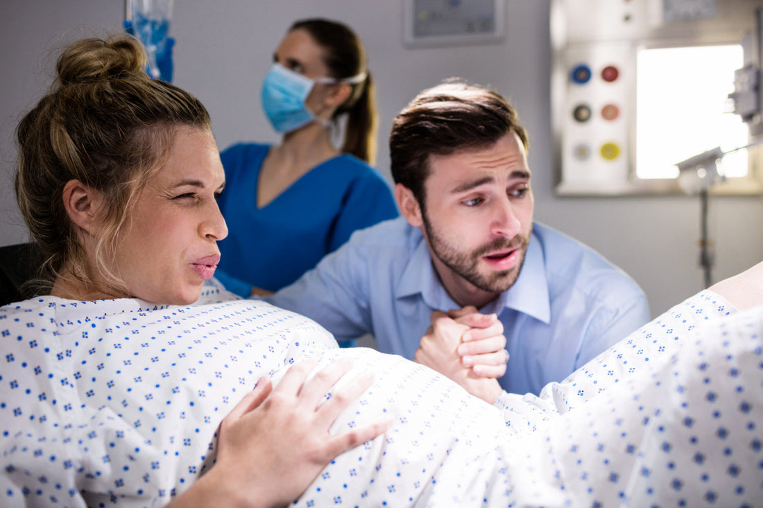 Femme enceinte en travail, réconfortée et soutenue par une personne, illustrant un moment de tendresse et d'accompagnement pendant l'accouchement.